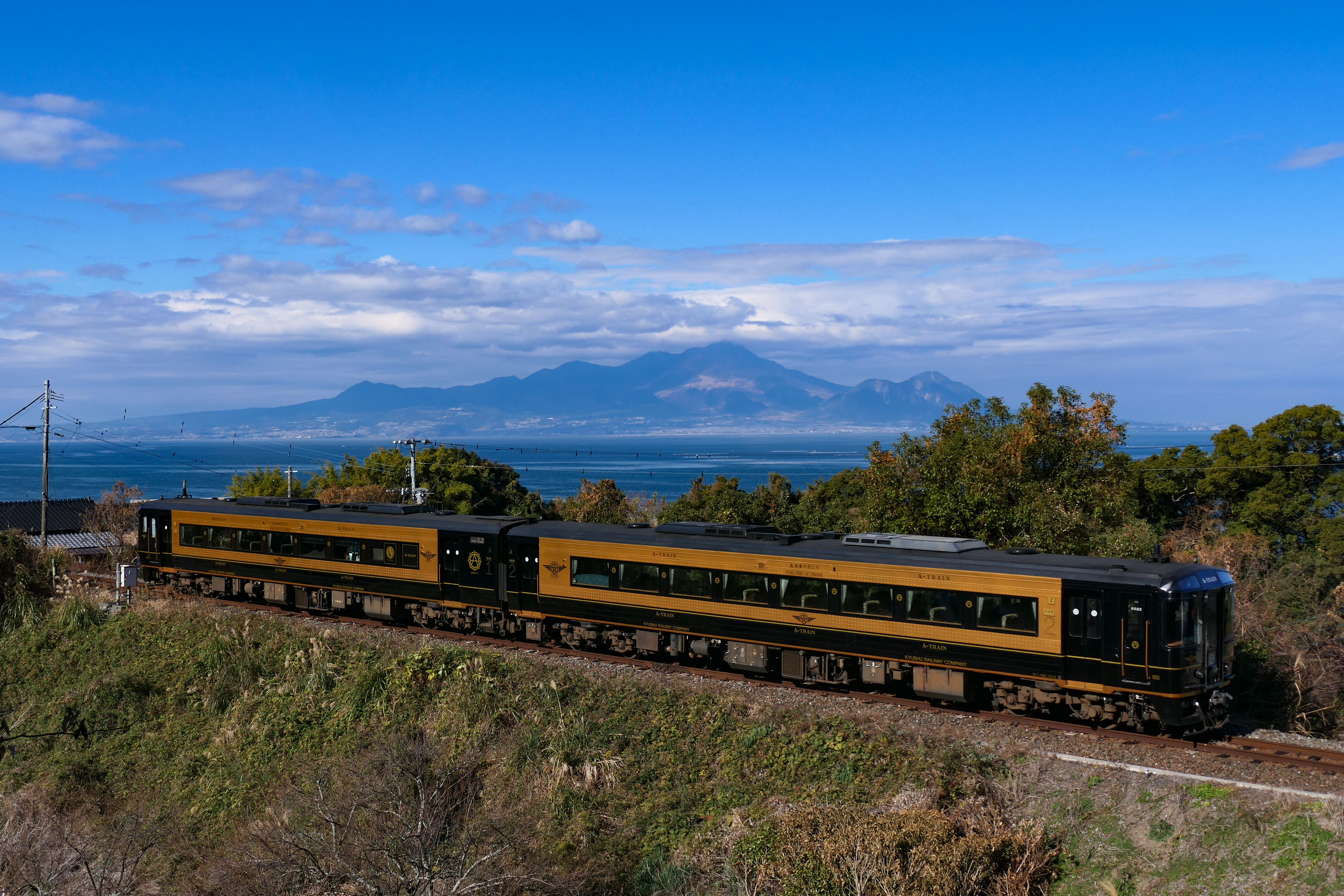 JR Kyushu A-Train running on the Misumi Line between Oda and Akase with the Ariake Sea and Mount Unzen in the background.