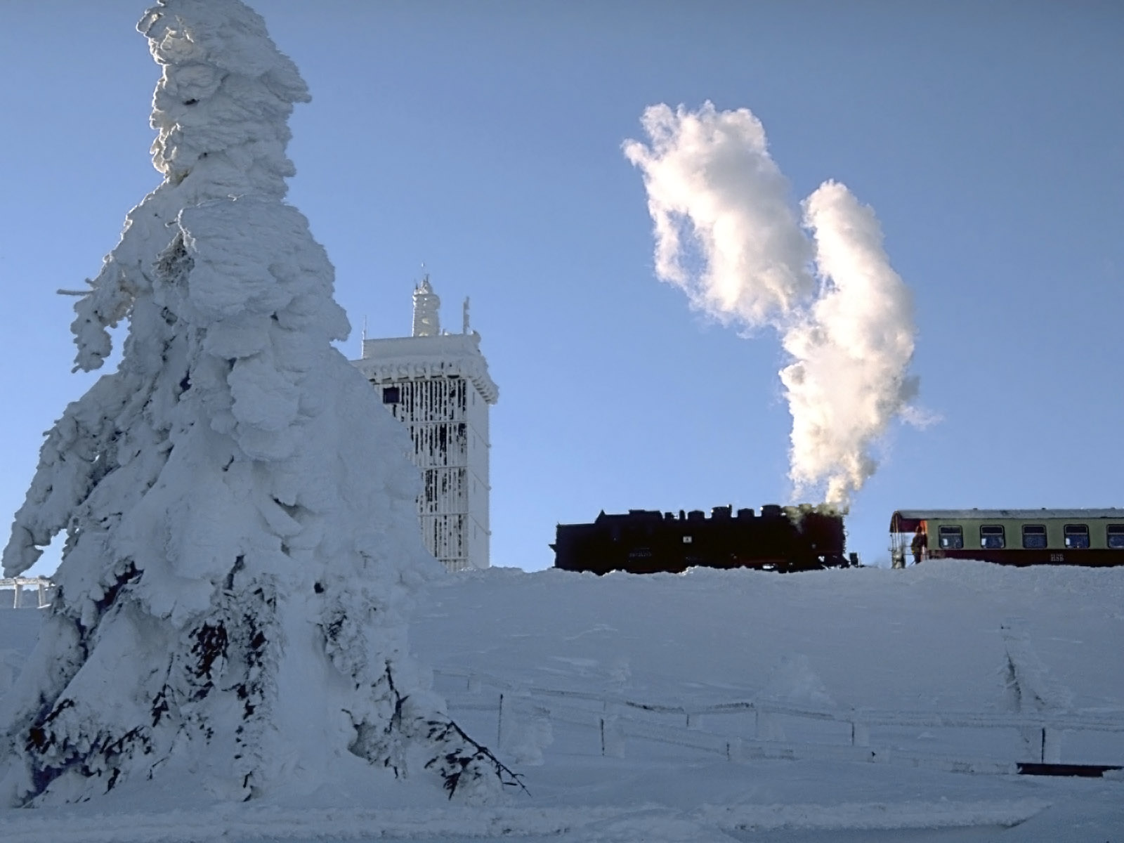 A steam train on the Brocken Railway crossing the snow-covered Brocken in Germany.