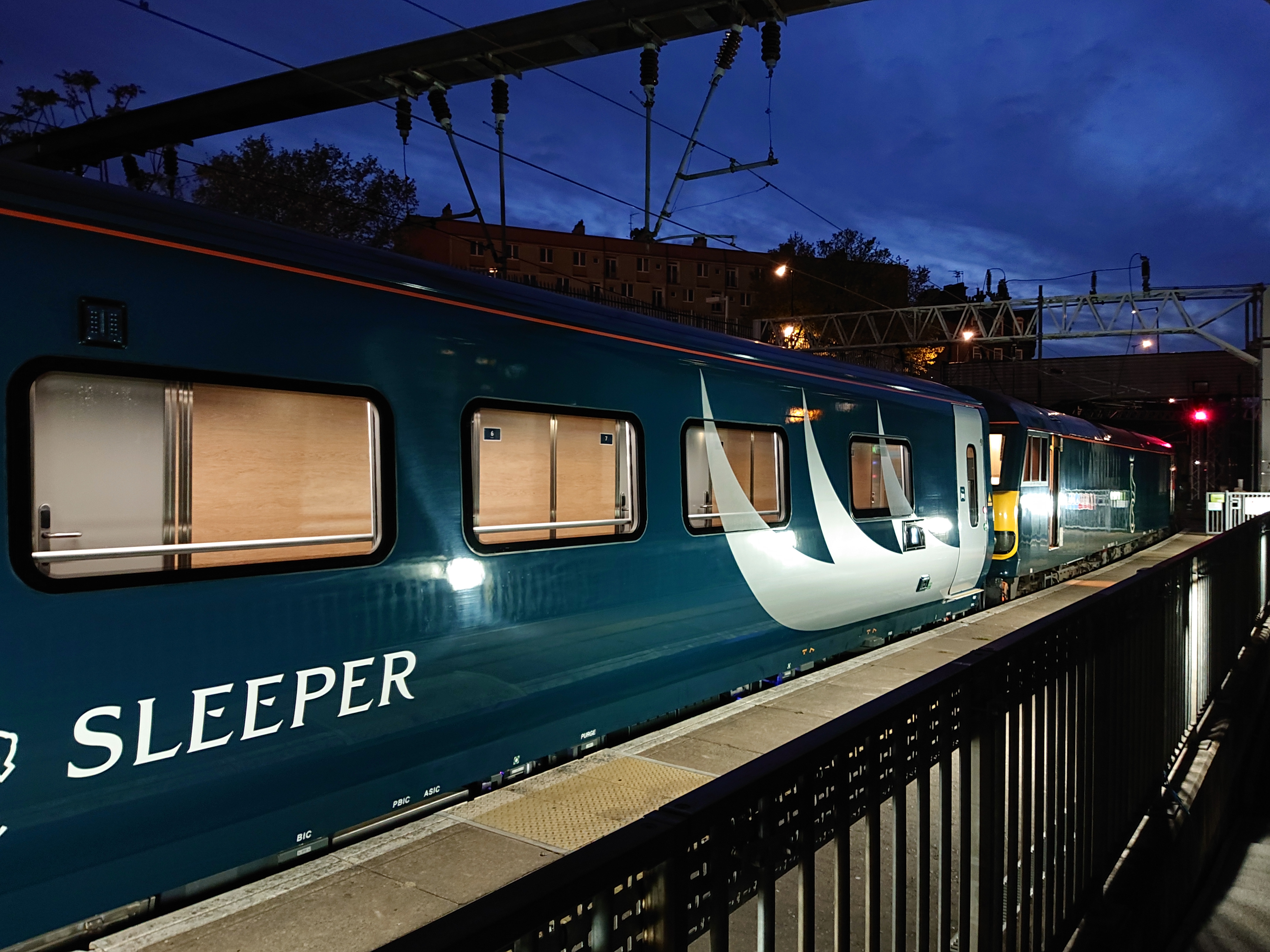 Current-generation Caledonian Sleeper Mk5 coaches with a Class 92 locomotive at London Euston.