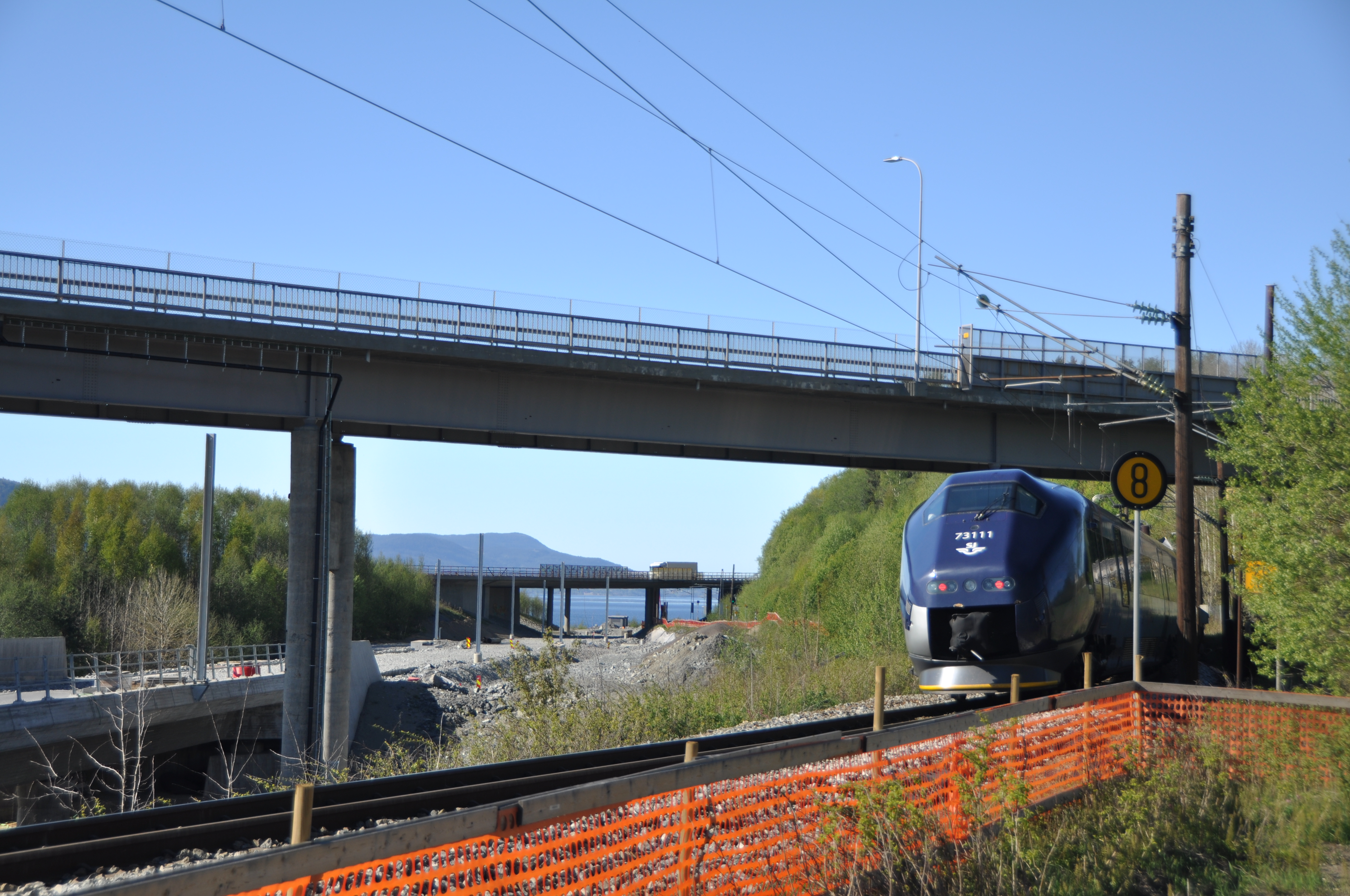 An SJ passenger train on the Dovre Line beneath Langset bridge in Norway in 2022.