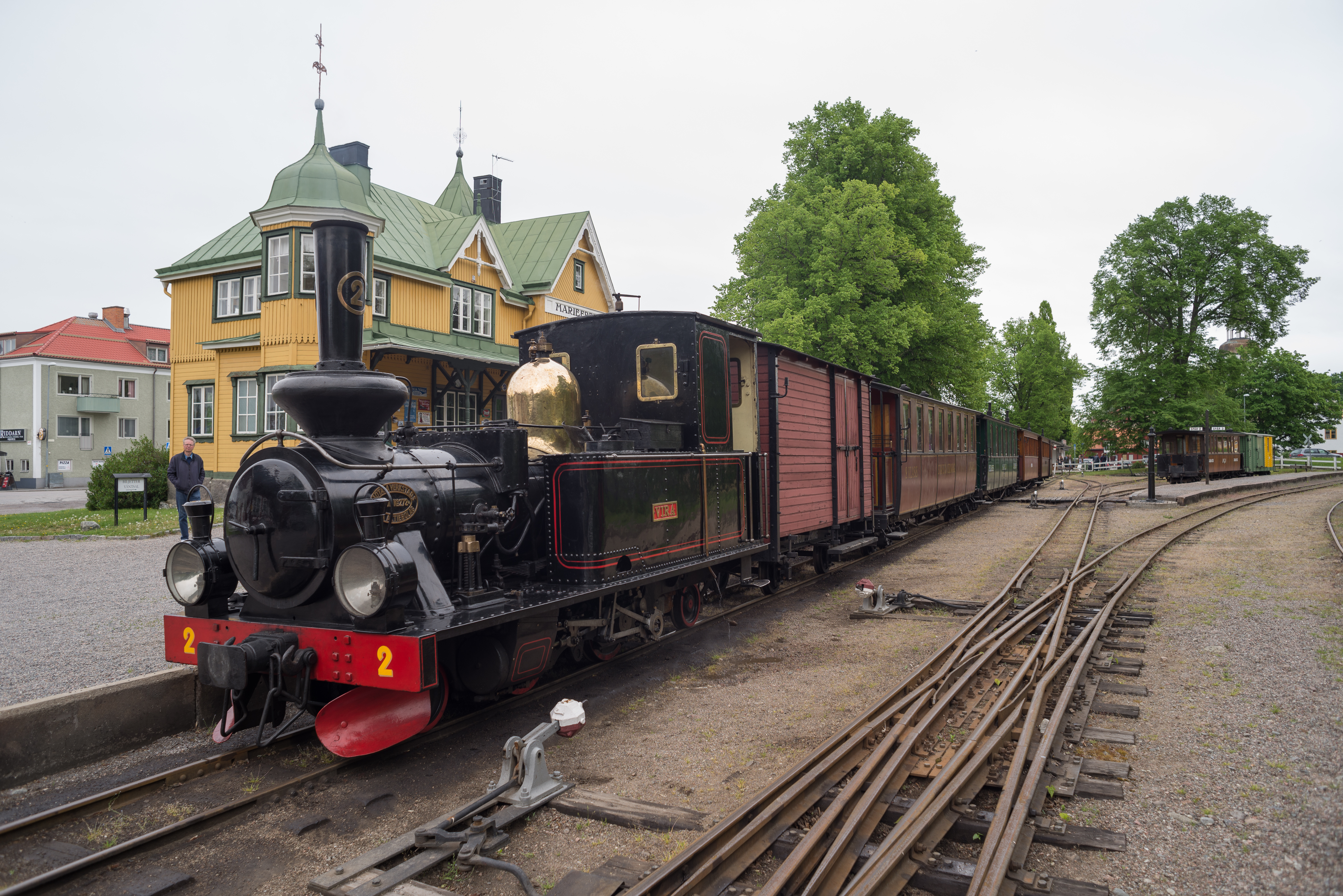 A 600 mm gauge steam locomotive and train of Östra Södermanlands Järnväg standing at Mariefred station.
