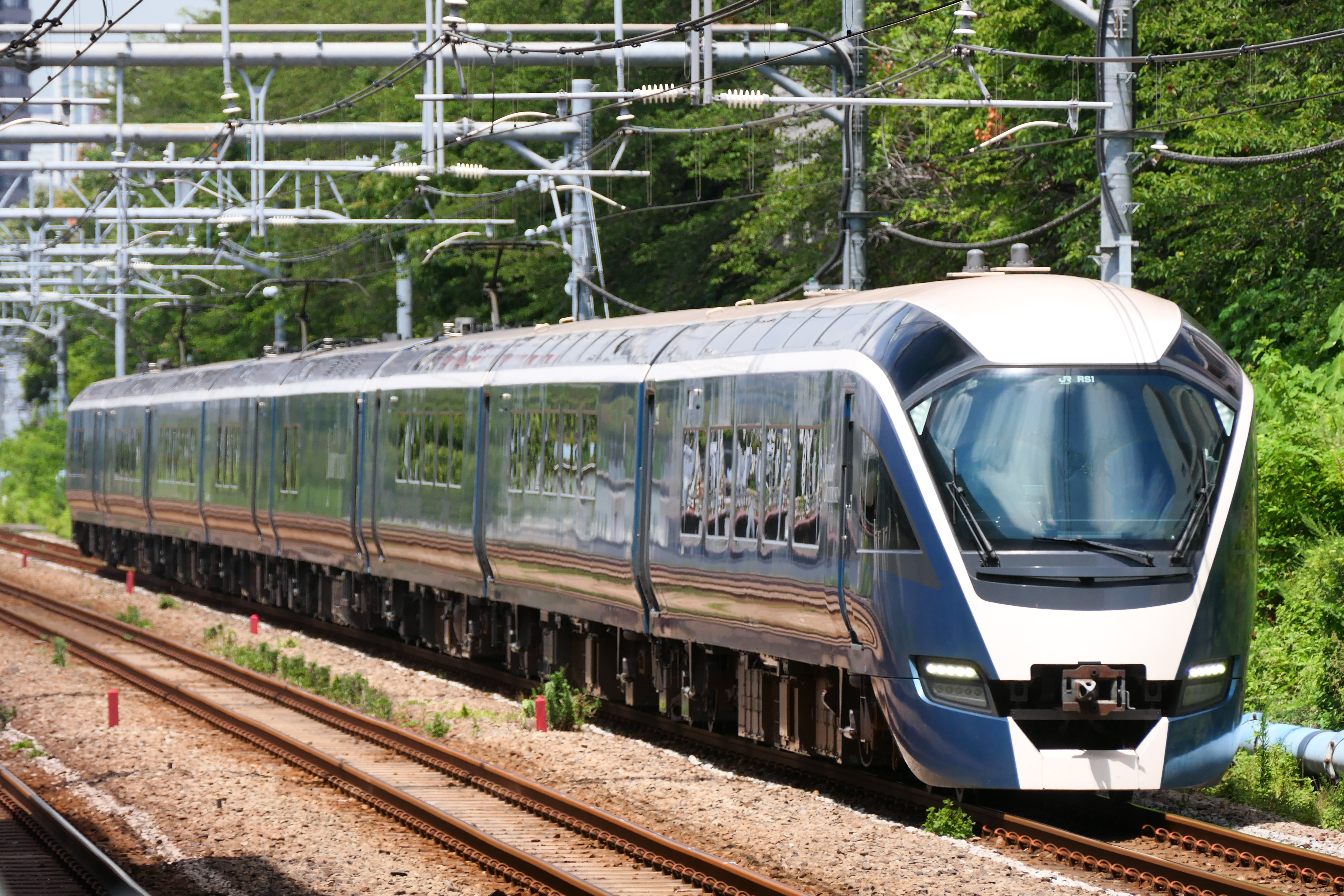 The blue E261 series SAPHIR ODORIKO running on the Tokaido main line in Tokyo.