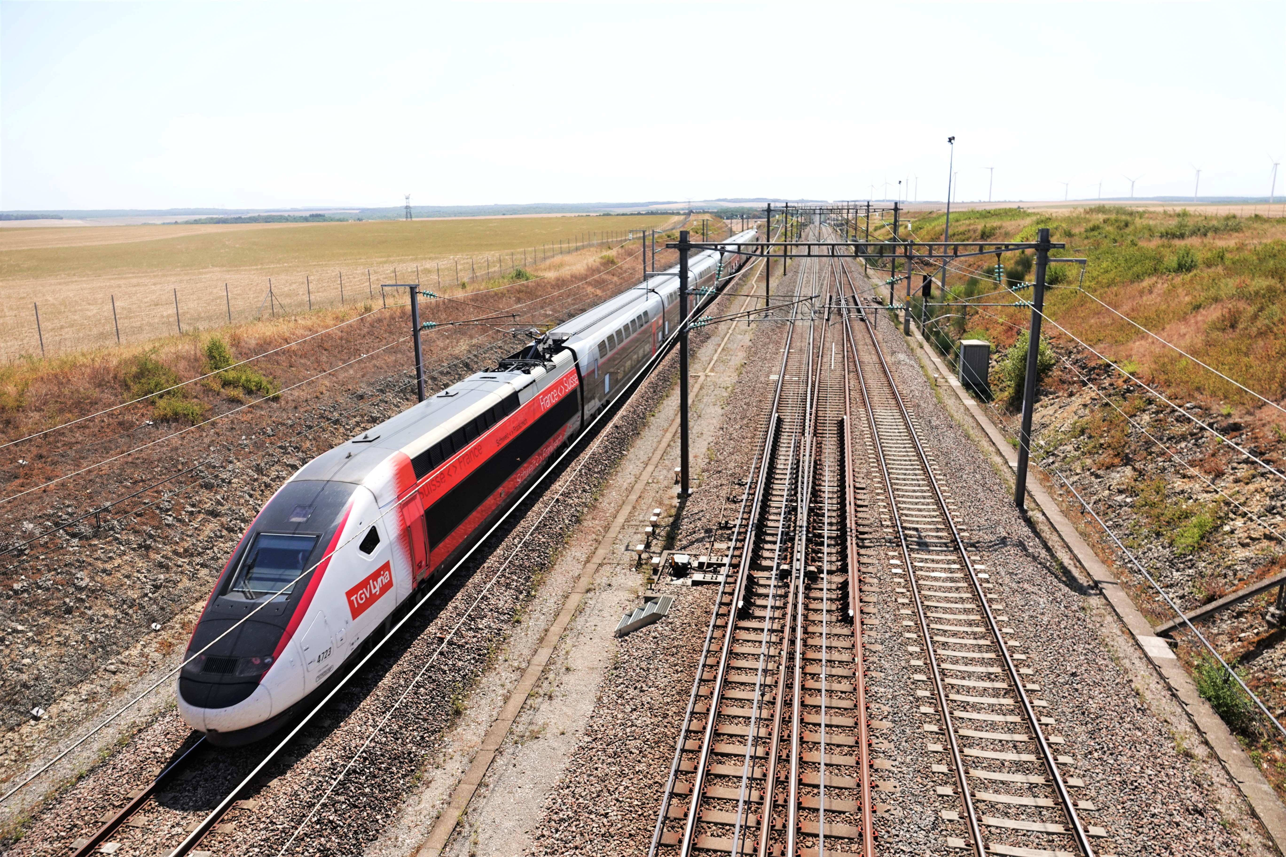 A TGV Lyria double-deck Euroduplex set running at speed through open country in Burgundy.