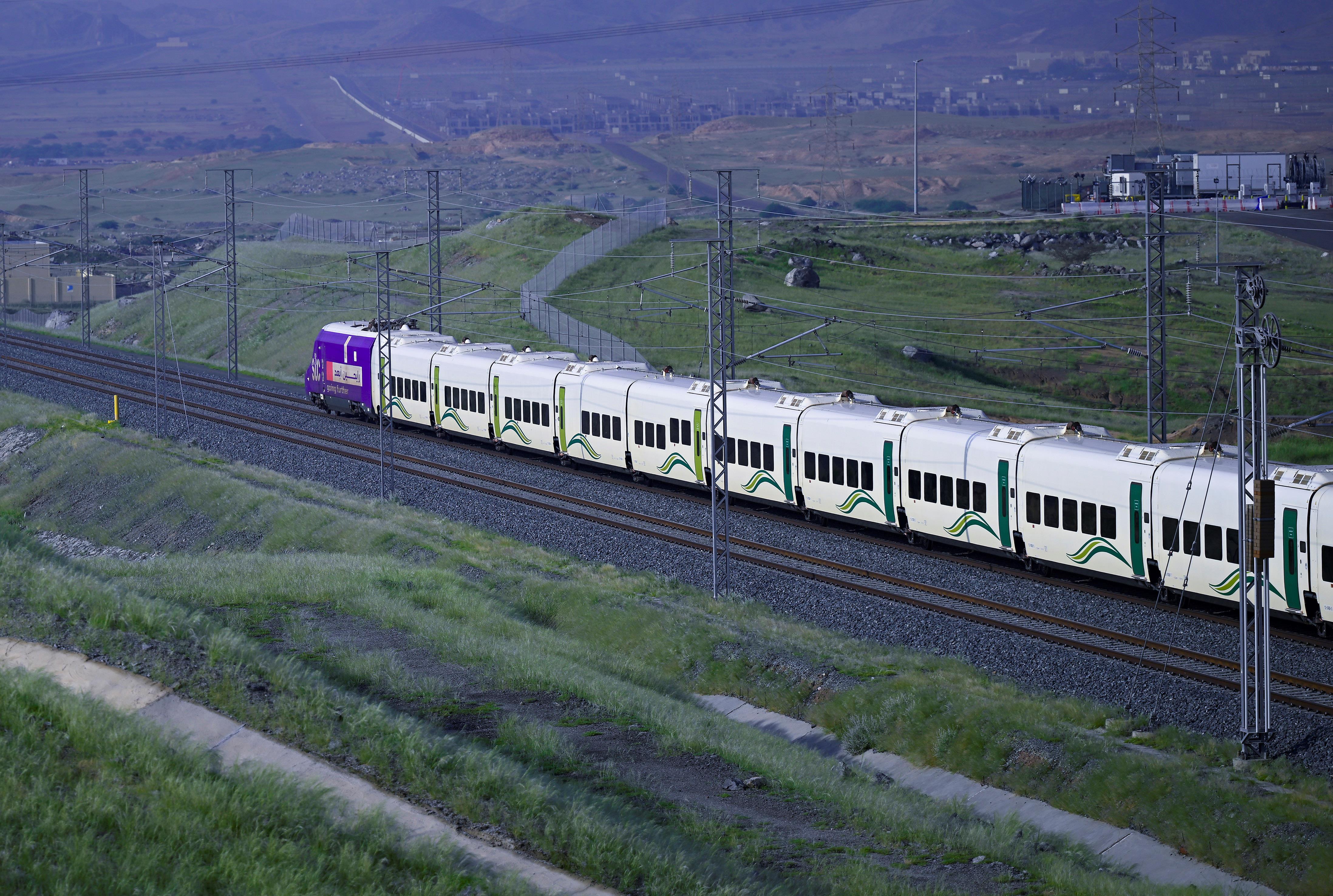 A Haramain high-speed train running through open country between Makkah and Madinah.