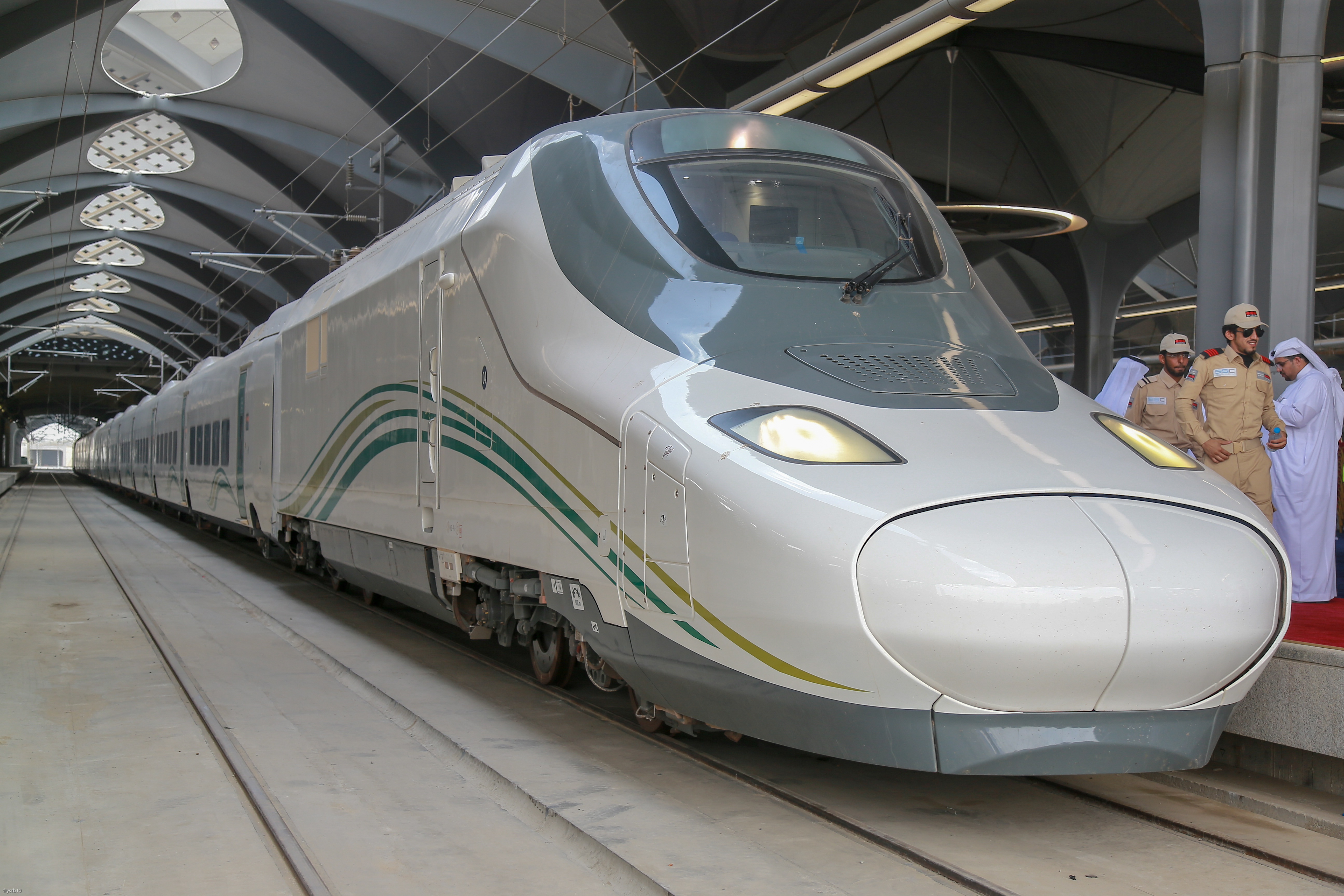 A Haramain high-speed train stands beneath the patterned roof at a Saudi Arabian station.