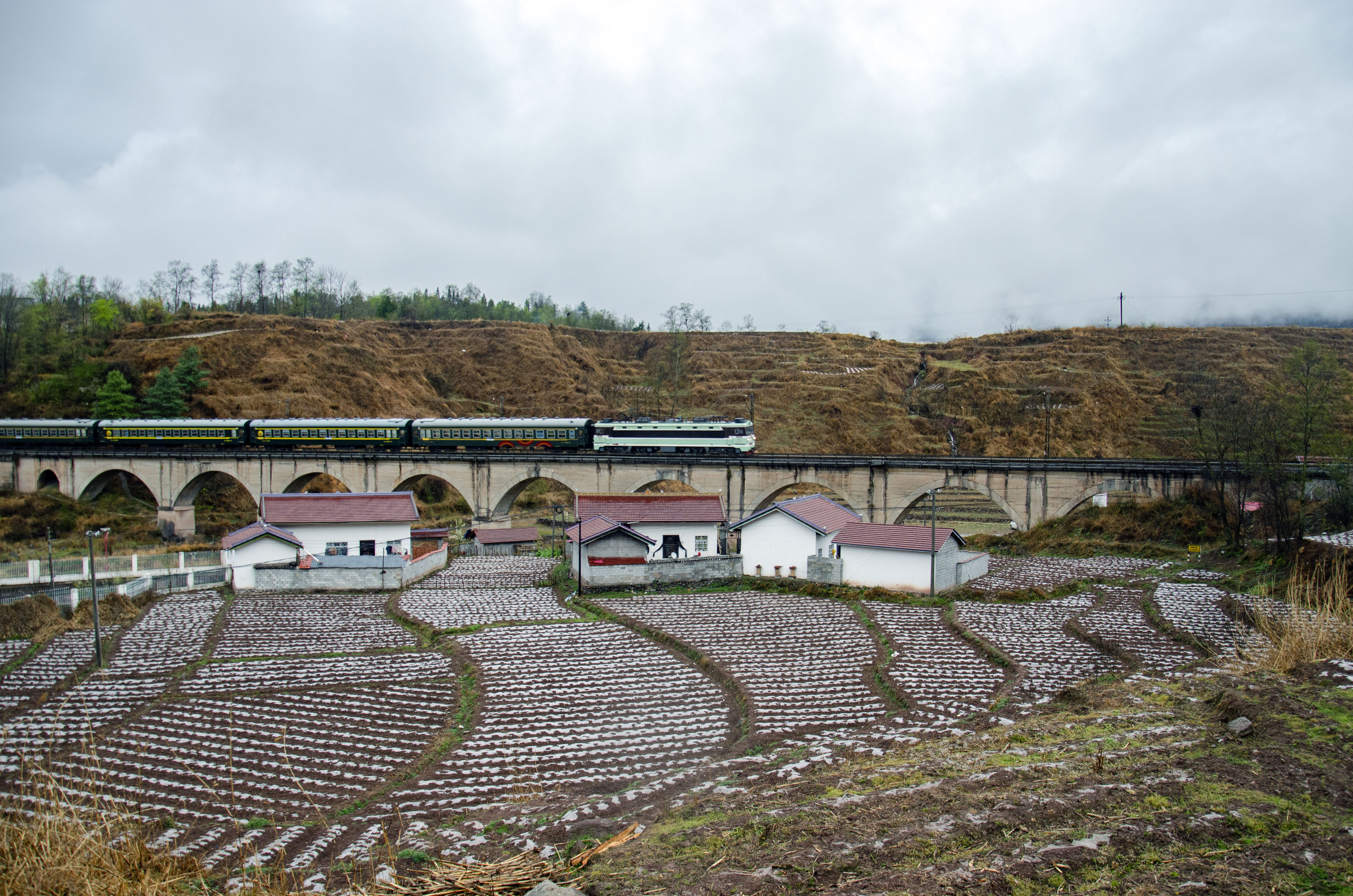 Puxiong–Panzhihua slow train 5633 crossing Shangpuxiong Bridge in the Daliang Mountains.