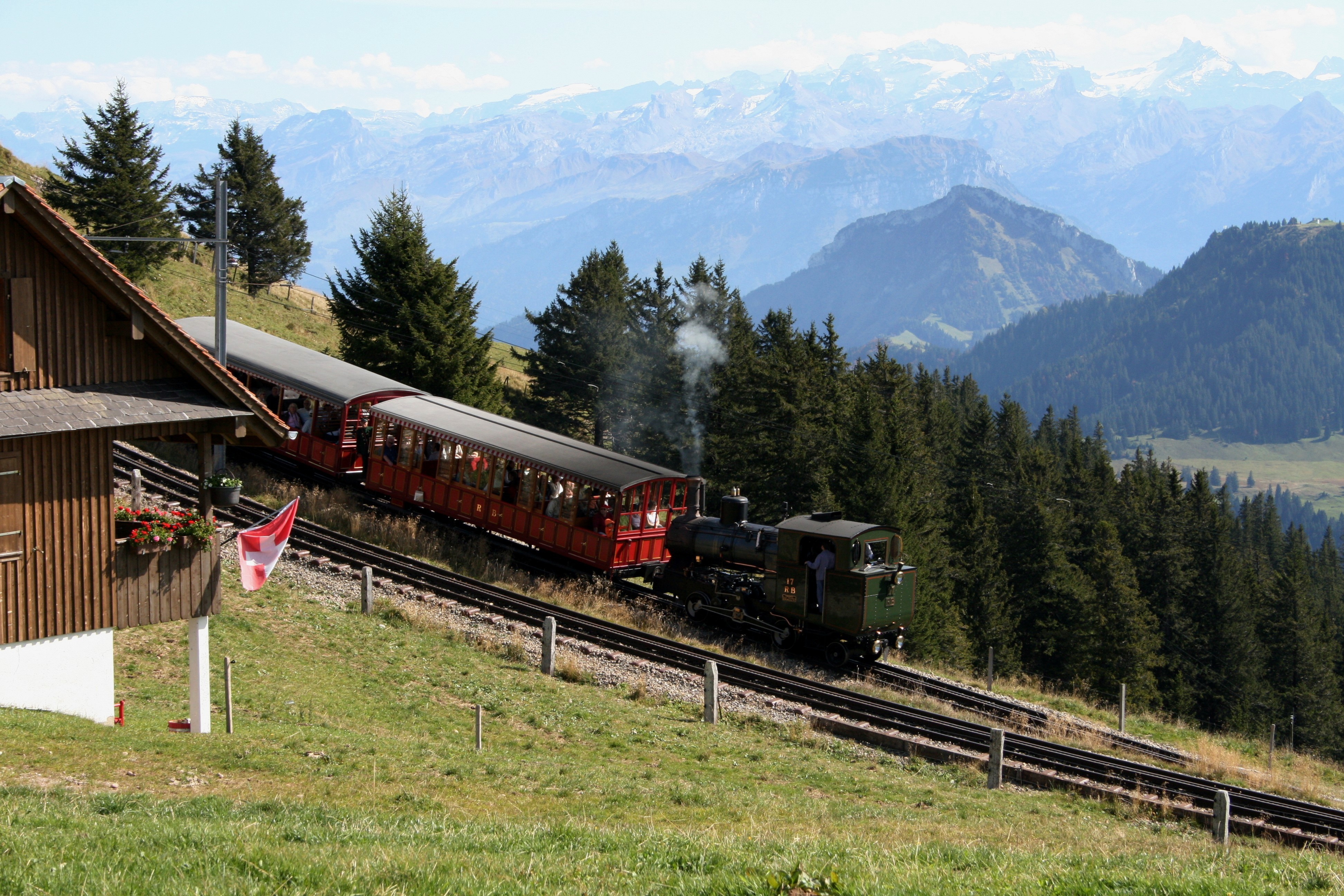 A steam train climbing the Rigi Railway through mountain scenery in Switzerland.