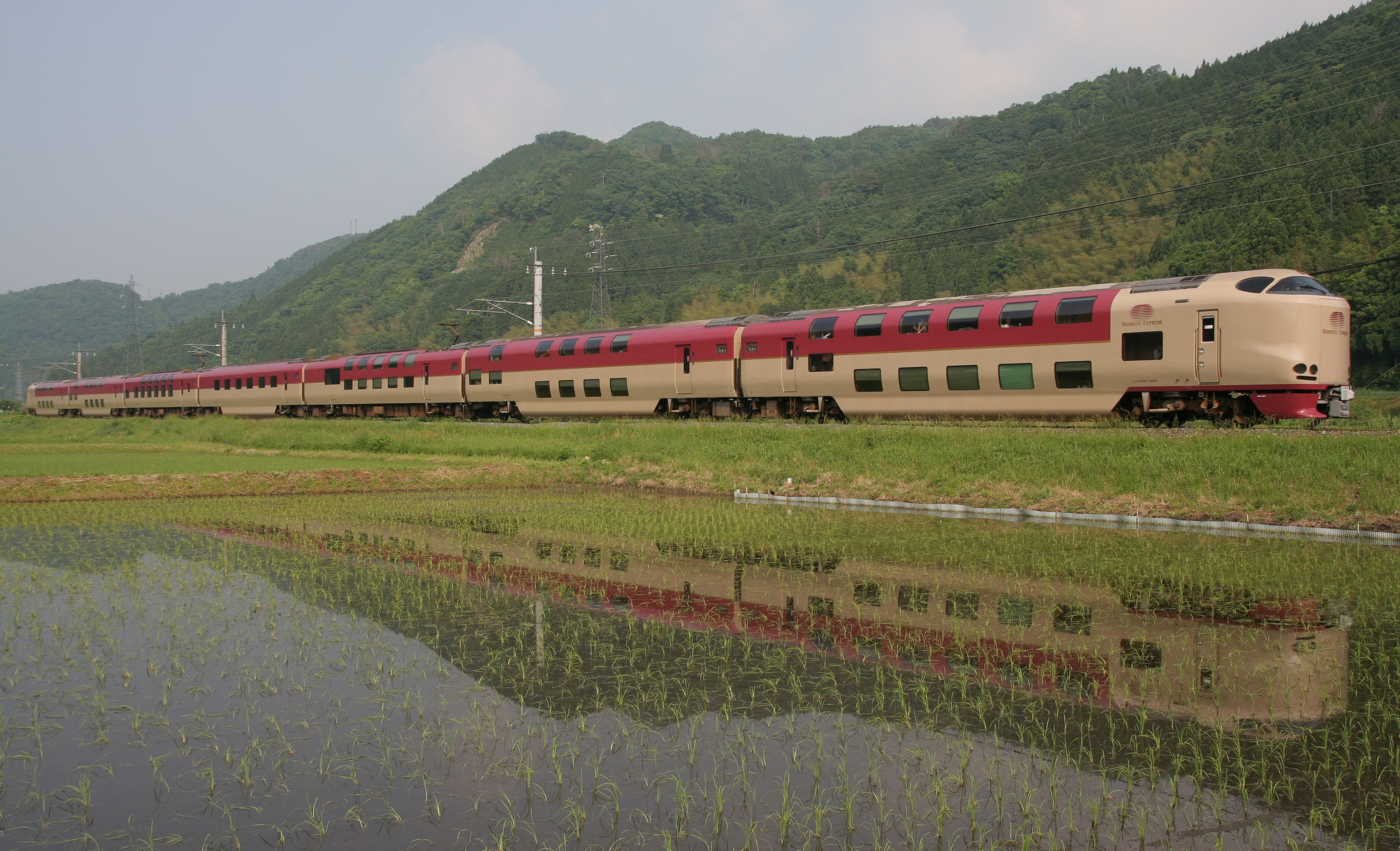 The Sunrise Izumo sleeper train passes flooded rice paddies in western Japan.