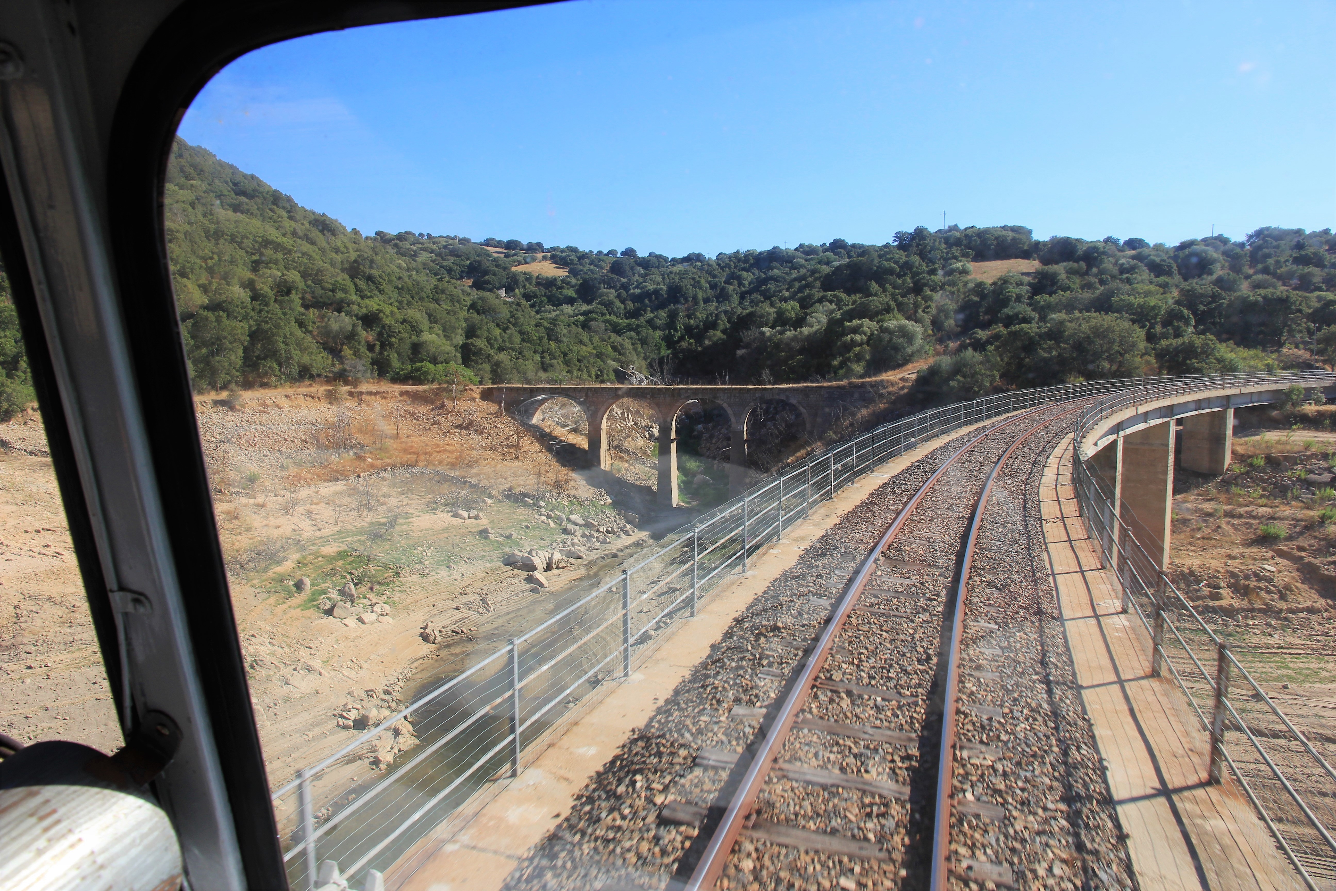 The green narrow-gauge Trenino Verde runs through the Sardinian countryside.