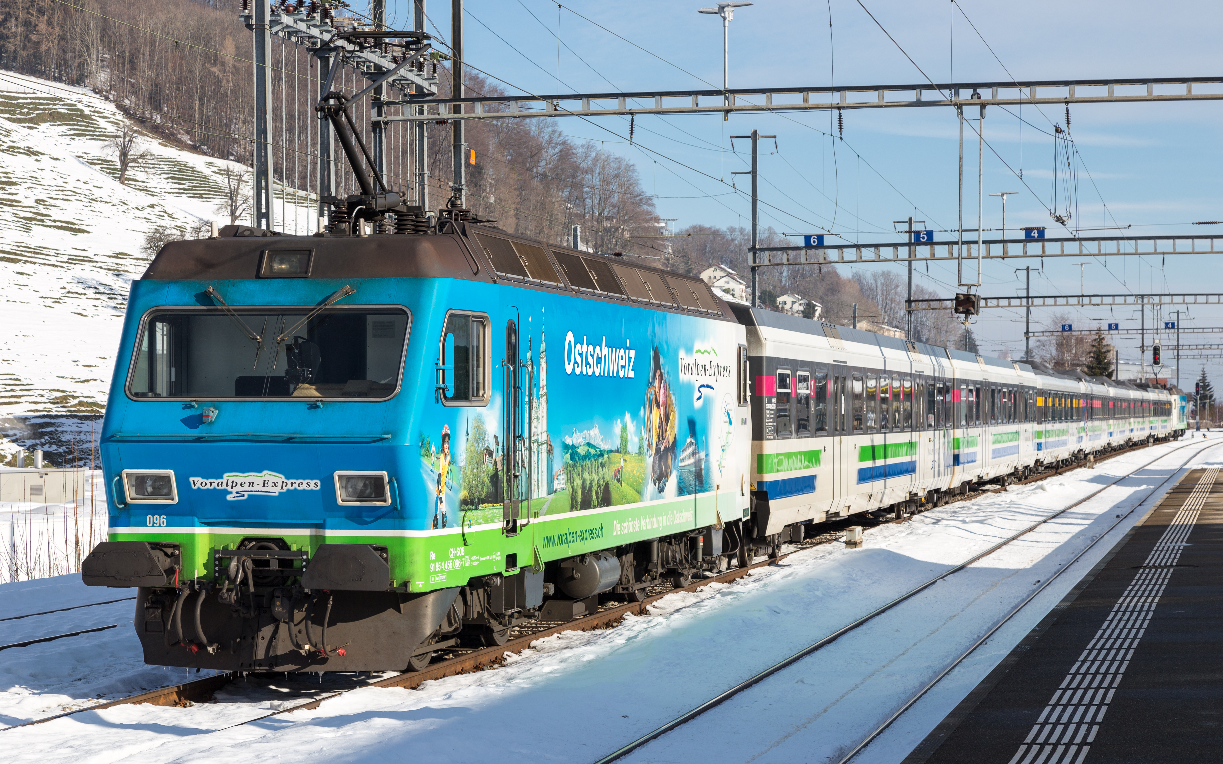 A red SOB Voralpen-Express train runs through the rolling countryside near Herisau.