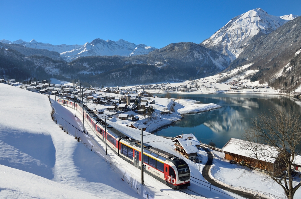 A Zentralbahn ADLER train beside Lake Lungern on the Luzern–Interlaken Express route in Switzerland.