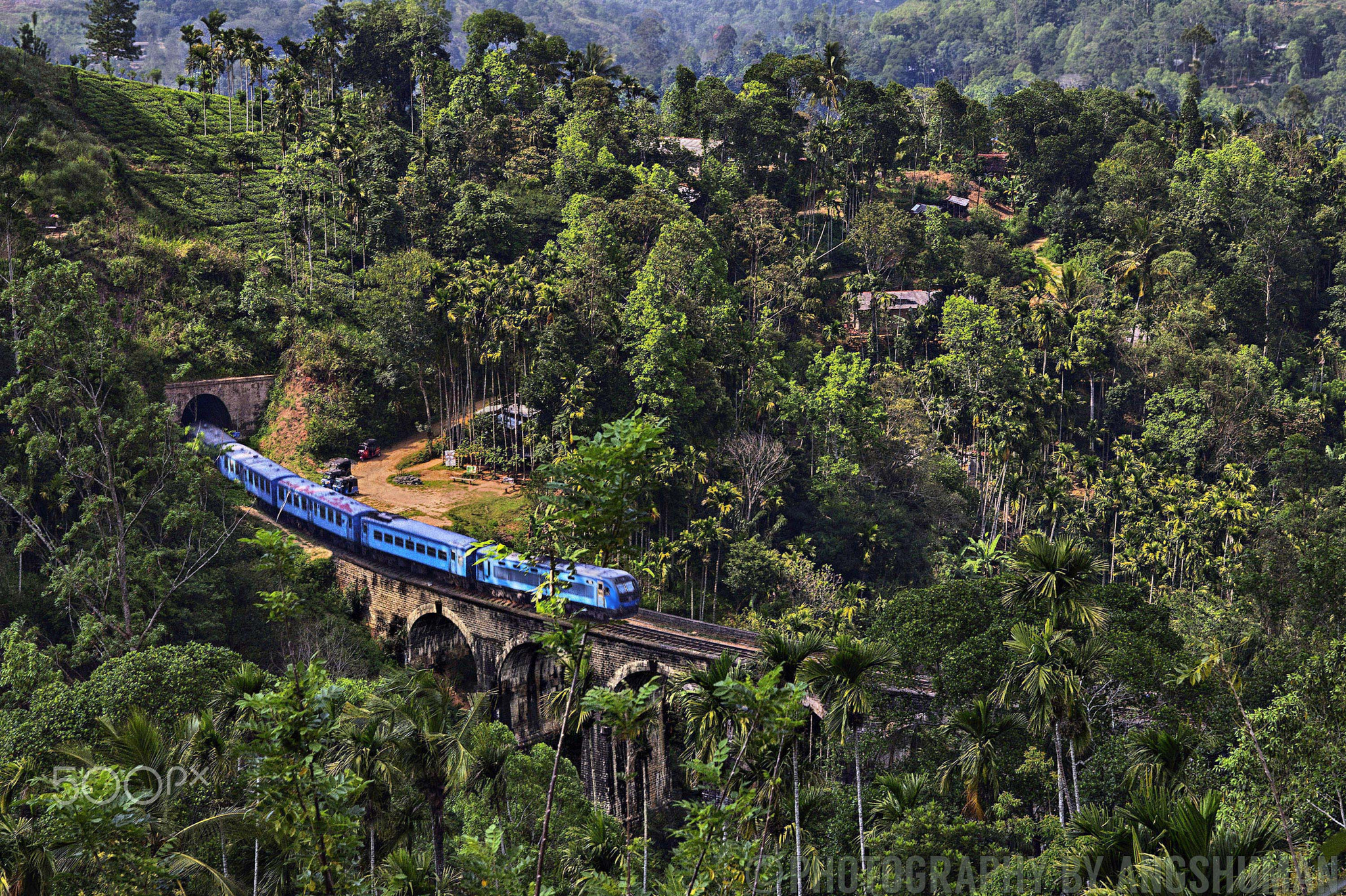 A blue Sri Lanka Railways train crosses Nine Arches Bridge near Ella.
