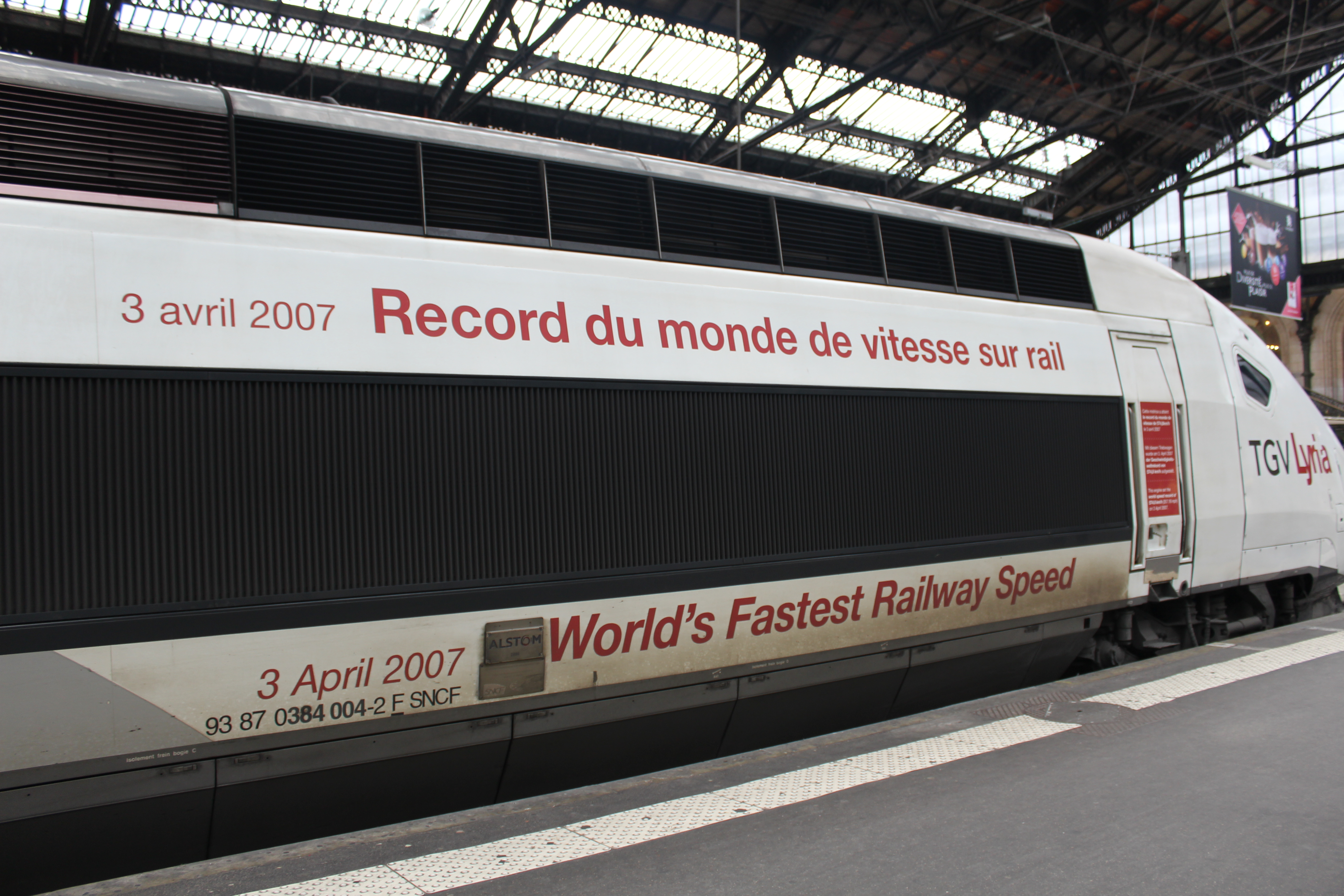 A TGV Lyria power car standing at Paris Gare de Lyon, lettered with the 2007 world rail speed record.