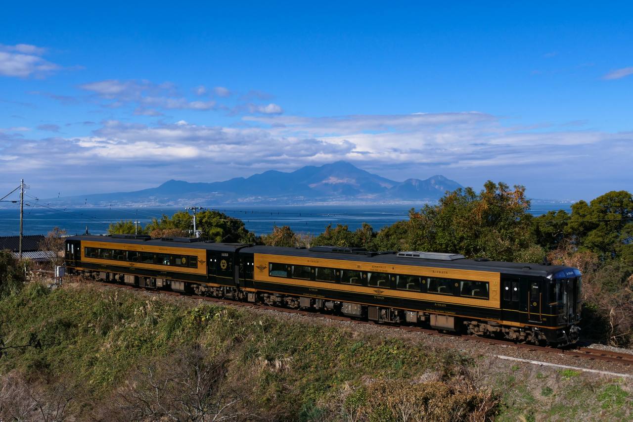JR Kyushu A-Train running on the Misumi Line between Oda and Akase with the Ariake Sea and Mount Unzen in the background.