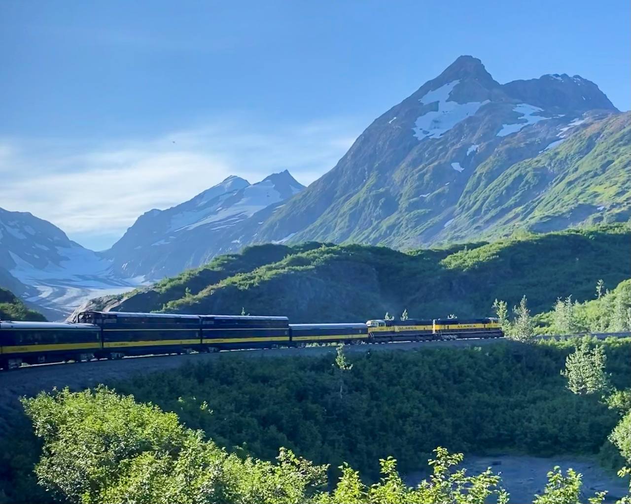 Alaska Railroad Coastal Classic winding through the S Curves toward Seward with Bartlett Glacier in the distance.