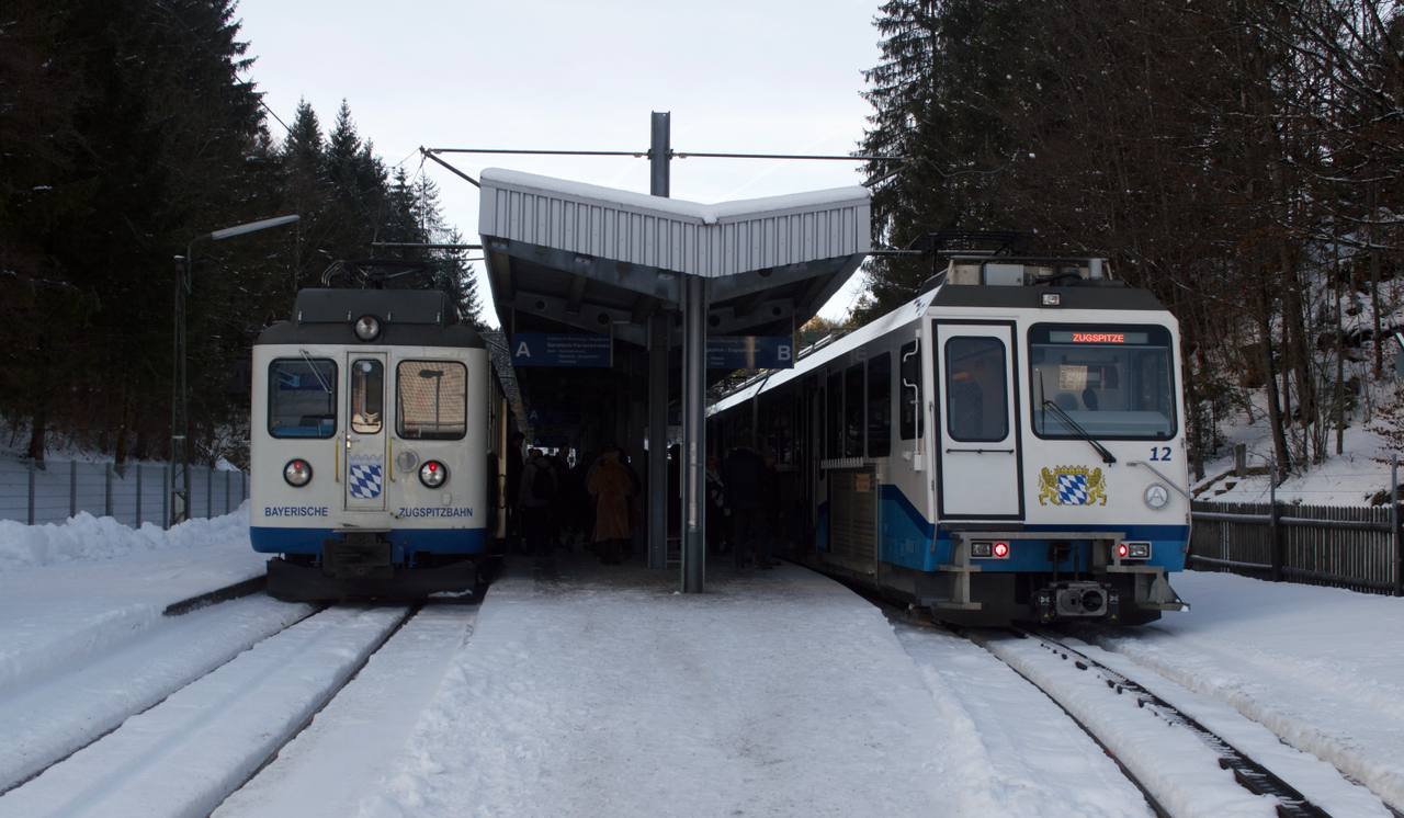 A Bayerische Zugspitzbahn train at Grainau below the snow-covered Wetterstein mountains.
