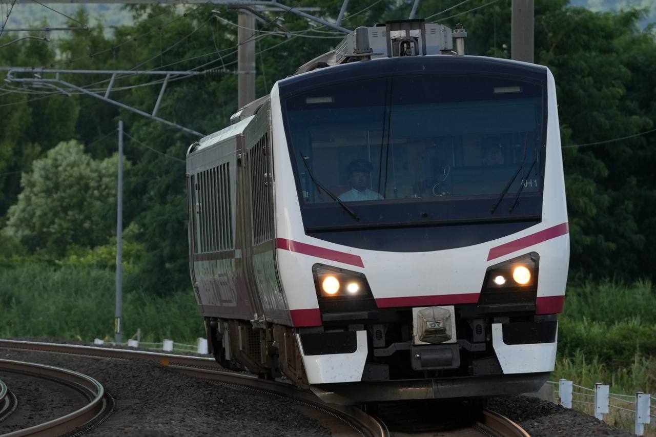The Hinabi sightseeing train rounding a curve through green countryside.
