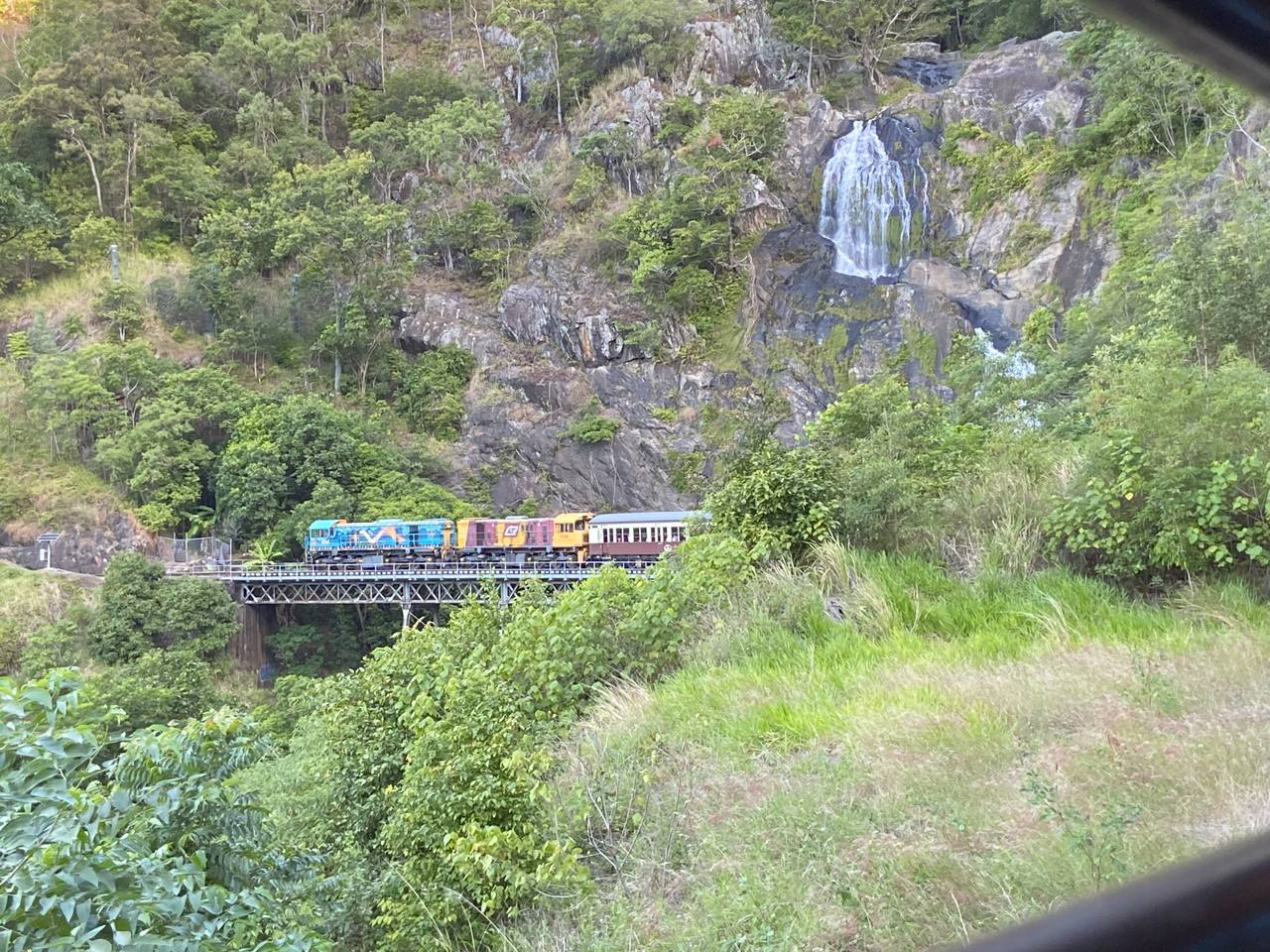 Kuranda Scenic Railway train crossing a bridge below Barron Falls.