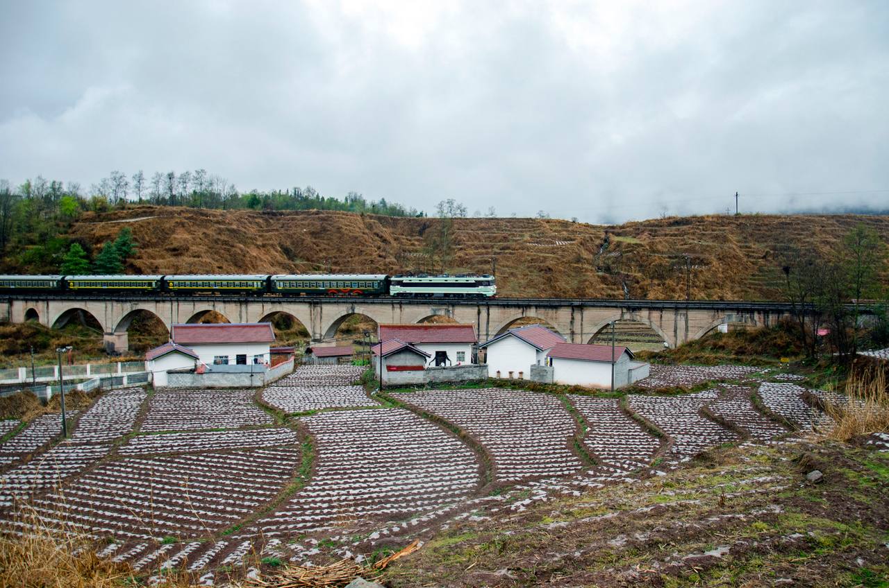Puxiong–Panzhihua slow train 5633 crossing Shangpuxiong Bridge in the Daliang Mountains.