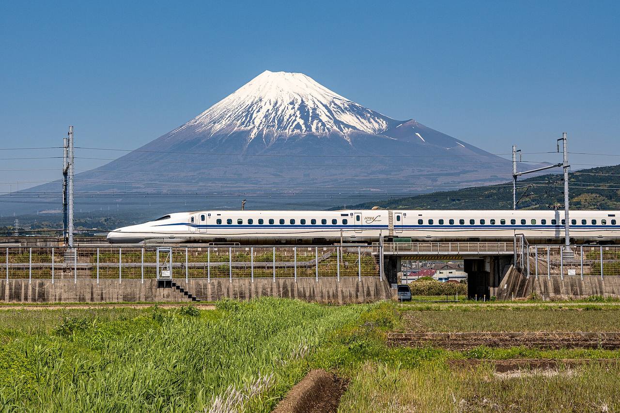 An N700S series Shinkansen on the Tokaido line at Higashi-Tagonoura, with Mount Fuji rising behind it.